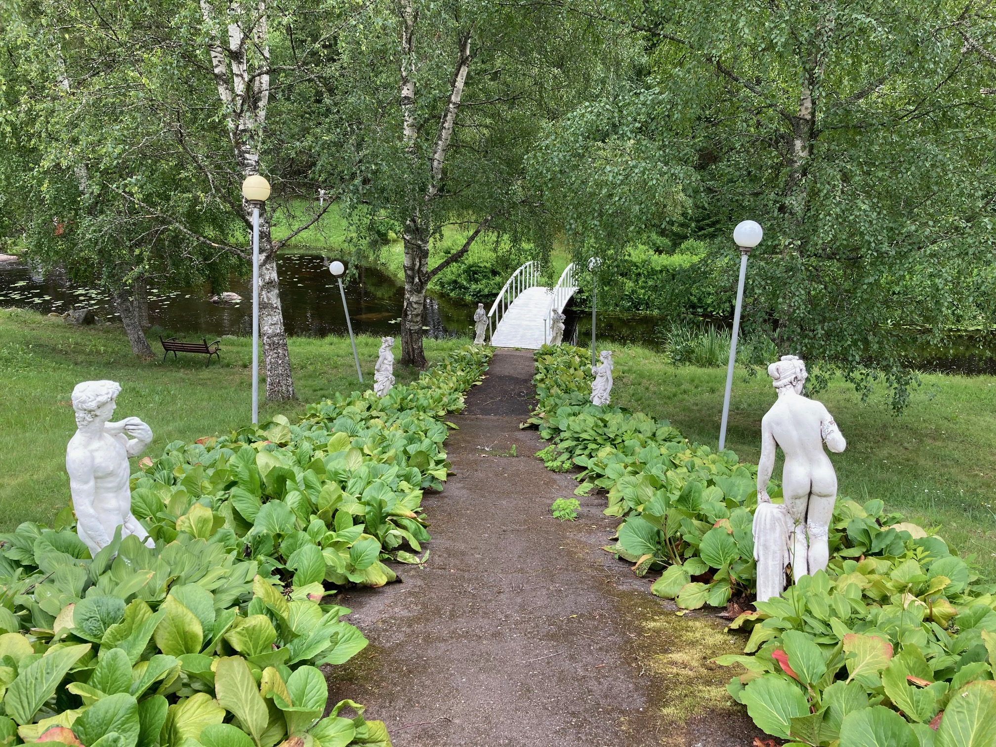 puiston keskellä menee tie, jonka reunoilla on patsaita ja pylväsvalaisimia