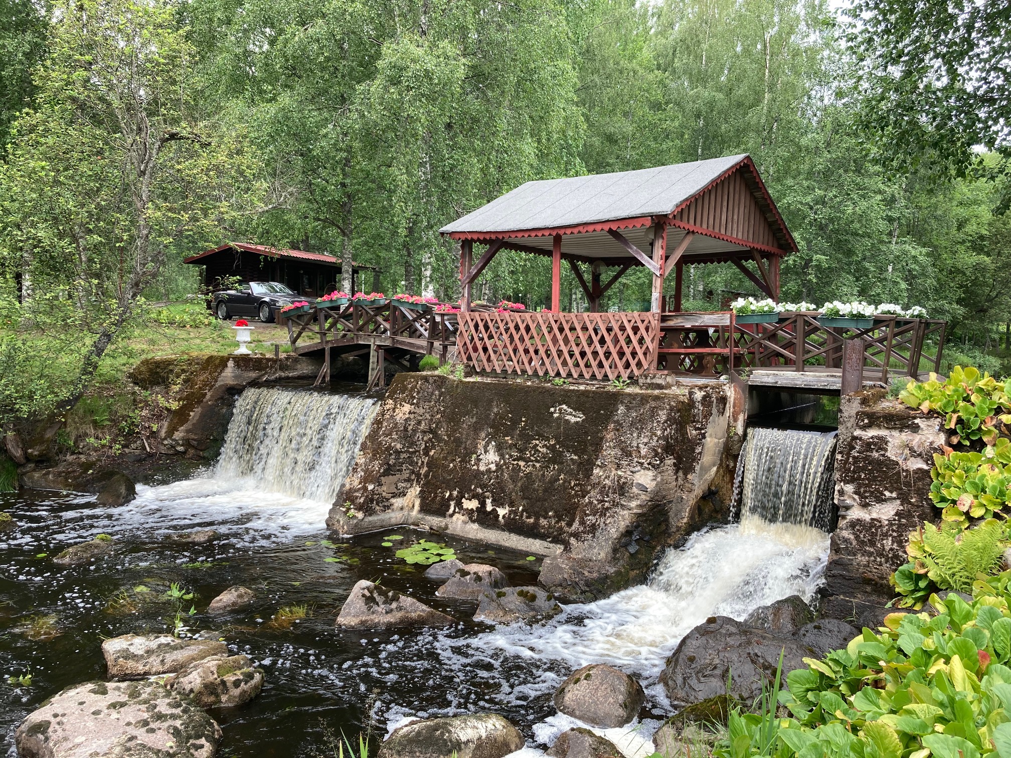 vanha rakennus joen ja vesiputouksen varrella